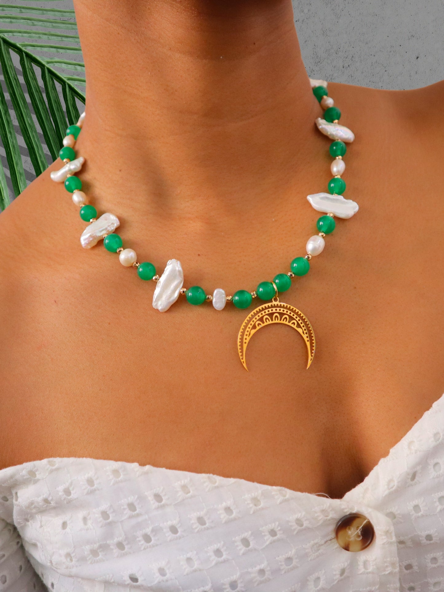 model posing in pearl and green moon necklace